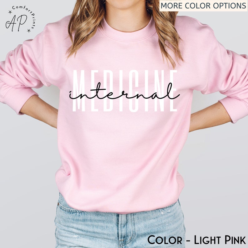 May include: A light pink sweatshirt with the text "INTERNAL MEDICINE" printed in white on the front.