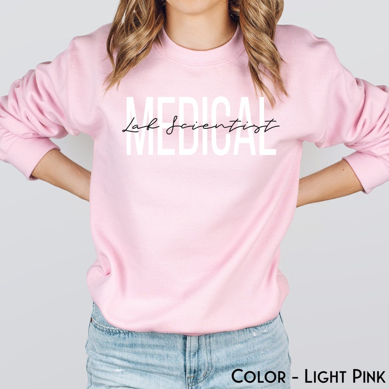 May include: A light pink sweatshirt with the text "Medical Lab Scientist" in white letters.