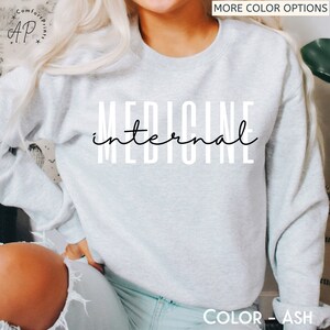 May include: A light gray sweatshirt with the text "internal medicine" printed in black.