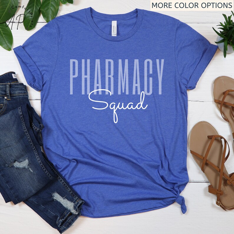 May include: A royal blue t-shirt with the text "Pharmacy Squad" in white. The text is in a bold, blocky font with the word "Squad" in a cursive font.