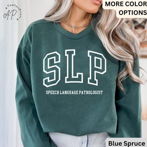 May include: A dark green sweatshirt with the text "SLP" in white, outlined in black, and the words "Speech Language Pathologist" in white below. The sweatshirt is made of a soft, comfortable material and has a relaxed fit.