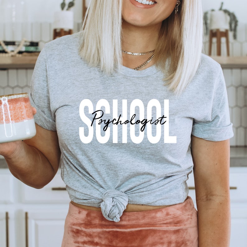 Op de afbeelding: Grijs T-shirt met de tekst "School Psychologist" in witte letters.