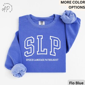 May include: A blue sweatshirt with the text "SLP" in white, which stands for "Speech Language Pathologist".