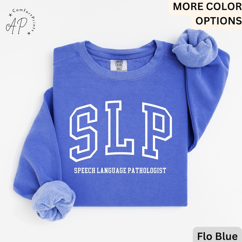 May include: A blue sweatshirt with the text "SLP" in white, which stands for "Speech Language Pathologist".