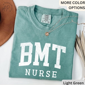 May include: Light green t-shirt with the text "BMT NURSE" in white. The shirt is made of a soft, comfortable material.
