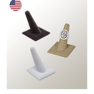 May include: Three ring display stands. One is black velvet, one is white velvet, and one is a natural linen fabric.
