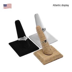 May include: Three ring display stands. One stand is black velvet, one is white velvet, and one is brown burlap.