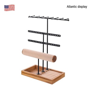May include: A wooden jewelry display stand with a black metal frame. The stand features multiple levels for hanging necklaces and earrings, a padded bar for bracelets, and a tray for rings. The text "Atlantic display" is visible.