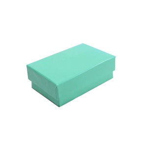 May include: A small, light turquoise gift box with a smooth, glossy finish.