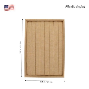 May include: A beige ring display box with 10 slots for storing rings. The box measures 9.4 inches by 13.8 inches.