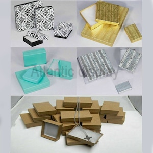 May include: Assortment of small jewelry boxes in various colors and patterns, including black and white damask, gold, silver, turquoise, and brown. The boxes are made of cardboard and have a variety of finishes, including glossy, matte, and textured.