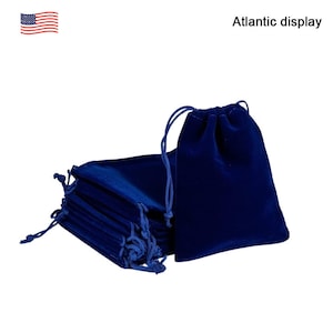May include: A stack of 10 small, dark blue velvet drawstring bags. The bags are made of soft, luxurious fabric and are perfect for storing small items like jewelry, gifts, or favors.