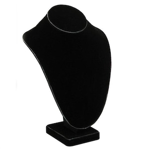 May include: A black velvet necklace display stand. The stand is shaped like a bust, with a rounded top for the neck and a rectangular base. The stand is designed to showcase necklaces and pendants.