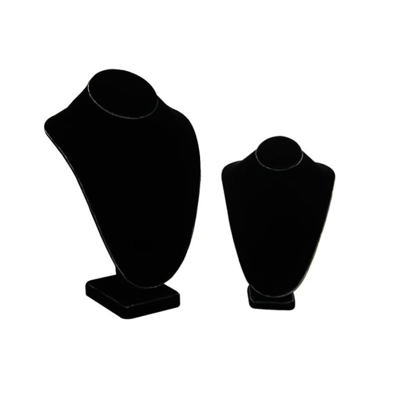May include: Two black velvet necklace display stands. The larger stand is taller and has a wider base. The smaller stand is shorter and has a narrower base.
