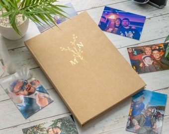 May include: A brown photo album with a gold floral design and the initials "M & N" on the front cover.