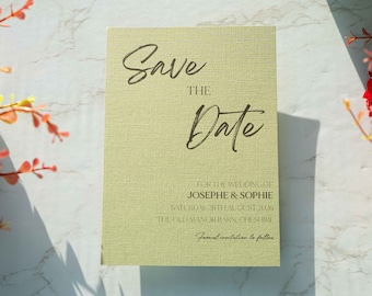 May include: Save the Date card with a light green background and brown text. The card says "Save the Date" for the wedding of "Josephe & Sophie" on Saturday, August 28th, 2026 at The Old Manor Barn, Cheshire. It also says "Formal invitation to follow."