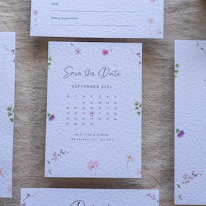 Elegante invito di nozze e set Save the Date con involucro in velina su carta di lusso strutturata con dettagli a forma di cuore