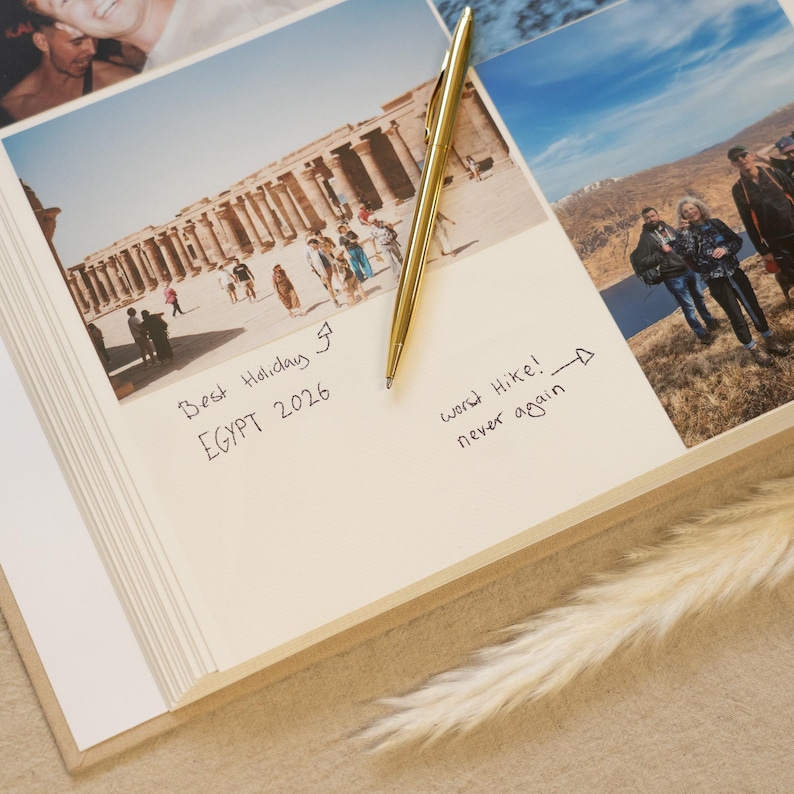 May include: A photo album open to a page with a photograph of an Egyptian temple and handwritten notes. A gold pen lies on the page. The text reads "Best Holiday Egypt 2026" and "Worst Hike! never again."