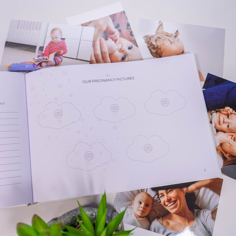 Puede incluir: Un &aacute;lbum de embarazo morado con el t&iacute;tulo "Nuestras fotos de embarazo" y seis espacios para fotos en forma de nube con iconos de c&aacute;mara. El &aacute;lbum est&aacute; abierto en la p&aacute;gina 7 y tiene una p&aacute;gina con l&iacute;neas a la izquierda y una p&aacute;gina en blanco a la derecha.