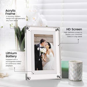 May include: A clear acrylic picture frame with a white mat and a built-in digital screen. The frame is displaying a photo of a wedding couple. The text "Acrylic Frame" is in the top left corner, "Lithium Battery" is in the bottom left corner, and "HD Screen" is in the top right corner.