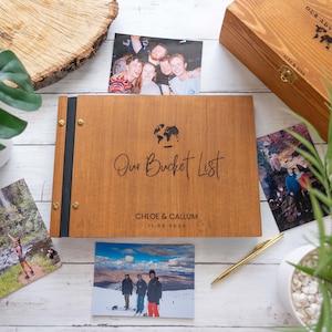 Könnte beinhalten: Ein Holzfotoalbum mit schwarzem Rücken und Messingakzenten. Das Album ist mit dem Text "Our Bucket List", "Chloe & Callum" und "11.08.2024" graviert.