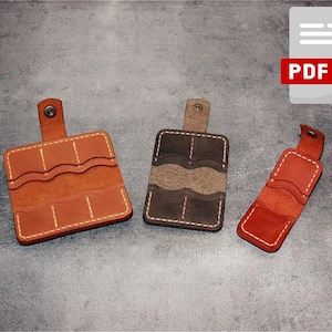 May include: Three leather card holders in different colors: brown, gray, and red. Each holder has multiple slots for cards and a snap closure.