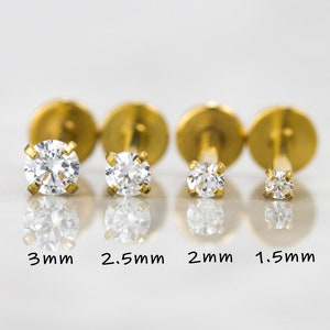 May include: Four gold-toned stud earrings with clear round stones. The stones are 3mm, 2.5mm, 2mm, and 1.5mm in size.