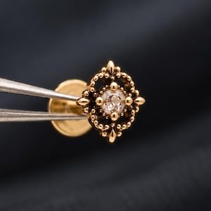 Piercing antiguo de oro con diseño floral: Pendiente sin rosca para tragus, hélix y concha con pátina oscura.