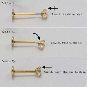 May include: A three-step guide on how to insert a gold body piercing with a clear gem. Step 1: Insert the pin halfway. Step 2: Slightly bend-in the pin. Step 3: Simply push the end to close.