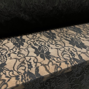 May include: Black lace fabric with a floral pattern. The lace is delicate and has a soft, flowing texture.