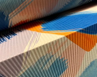 May include: Close-up of fabric with a striped pattern in shades of blue, orange, and beige. The fabric has a textured surface and a geometric design.