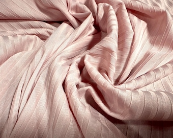 May include: A close-up of a soft, pink ribbed fabric. The fabric is wrinkled and has a subtle sheen.