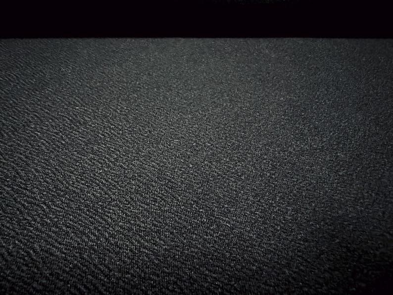 May include: A close-up of a black textured surface. The surface has a subtle pattern of small raised dots.