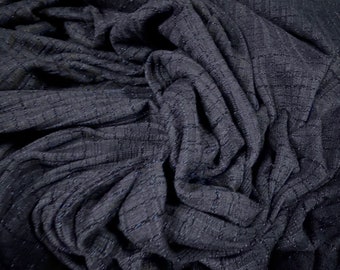 May include: Dark navy blue fabric with a textured, grid-like pattern. The fabric is draped, showing folds and shadows. The material has a subtle sheen, suggesting a blend of fibers. This textile is suitable for apparel or home decor.