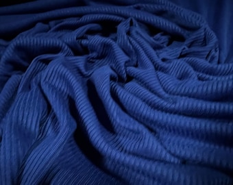 May include: Close-up of a deep blue ribbed fabric. The fabric is soft and has a subtle sheen.