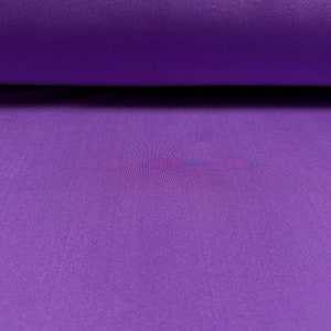 Pu&ograve; includere: Primo piano di un tessuto viola con una superficie leggermente strutturata.