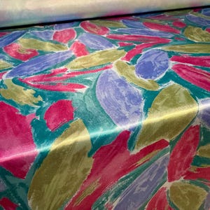 May include: Abstract floral print fabric in shades of pink, green, blue, and gold. The fabric has a satin finish.