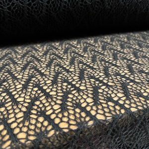 May include: Black lace fabric with a wavy, geometric pattern. The fabric is soft and delicate, and it would be perfect for a variety of projects, such as clothing, accessories, and home decor.