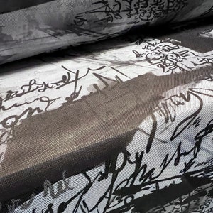 May include: Black and white fabric with a graphic print of abstract shapes and scribbles. The fabric has a mesh texture.