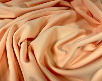 May include: Peach coloured fabric with soft folds and wrinkles.