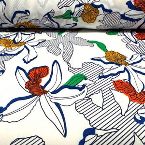 May include: White fabric with a repeating pattern of blue, green, orange, and red stylized flowers. The flowers are outlined in black and have a striped background.