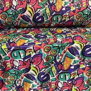 May include: White fabric with a colorful, abstract, graffiti-style print. The print features swirls, geometric shapes, and the repeated text "Hot Mess".