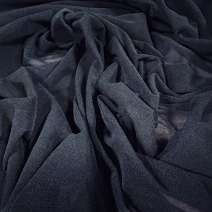 Peut inclure: Un gros plan sur un tissu transparent bleu foncé, montrant la texture et le drapé du matériau.
