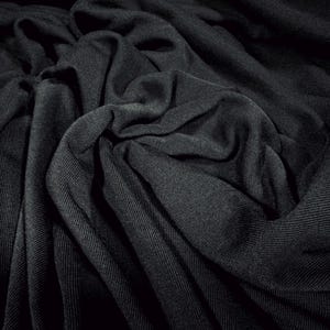 May include: Close-up of a black fabric with a textured, wrinkled surface. The fabric is soft and drapey, creating a luxurious and elegant look.