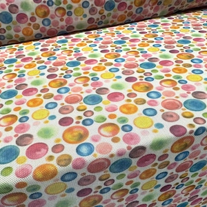 Può includere: Tessuto bianco con un motivo ripetitivo di cerchi colorati in stile acquerello. I cerchi sono di varie tonalità di rosa, blu, giallo, verde e arancione.