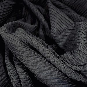 May include: Close-up of a black ribbed fabric with a textured, crinkled surface.