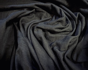 May include: Close-up of a dark gray fabric with a soft, wrinkled texture. The fabric is draped and folded, creating a sense of depth and dimension.