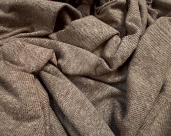 May include: Close-up of a brown ribbed fabric with a textured surface. The fabric is folded and draped, creating a soft and cozy look.