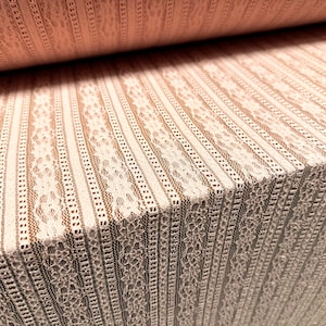 May include: White lace fabric with vertical stripes. The fabric has a delicate floral pattern.
