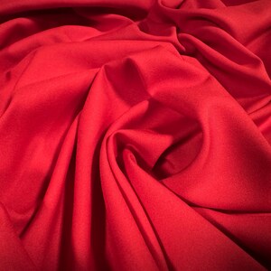 Pode incluir: Um close-up de um tecido vermelho liso com dobras e rugas suaves.